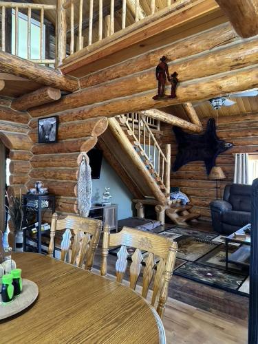 a dining room with a table in a log cabin at Sportsman Lodge Melrose MT in Melrose