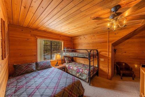 um quarto com um beliche num chalé de madeira em Cabin #5 Black Bear - Pet Friendly - Sleeps 6 - Playground & Game Room em Payson