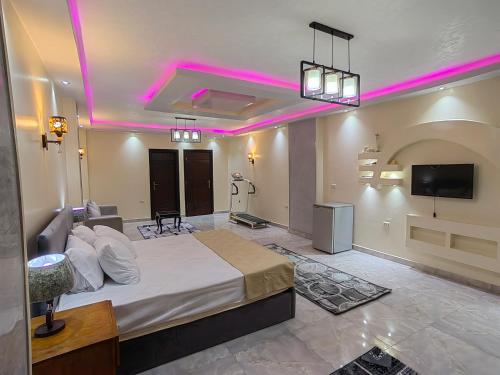 a bedroom with a large bed with pink lighting at Gem Overlooking inn in Cairo