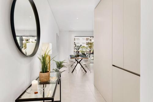 a hallway with a mirror and a table at 2-Bedroom Beachside Apartment with Pool & Parking in Quarteira