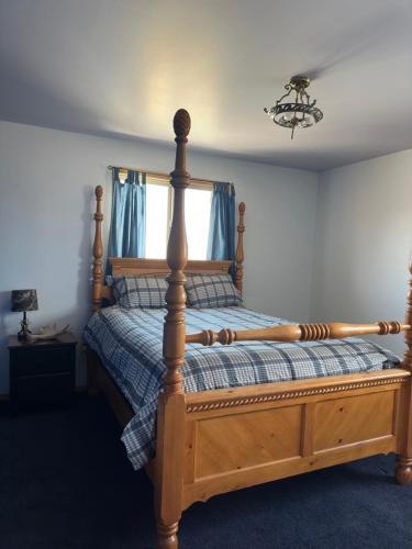a bedroom with a wooden bed with a wooden frame at Sportsman Lodge Melrose MT in Melrose