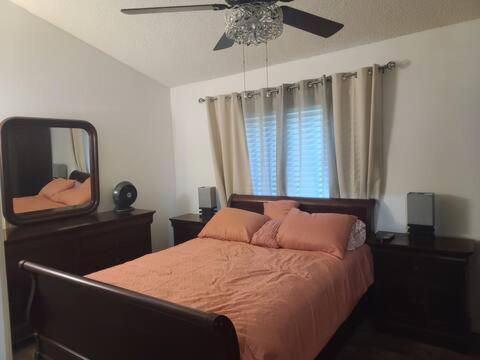 a bedroom with a bed with a mirror and a ceiling fan at GCRetreat in Upland