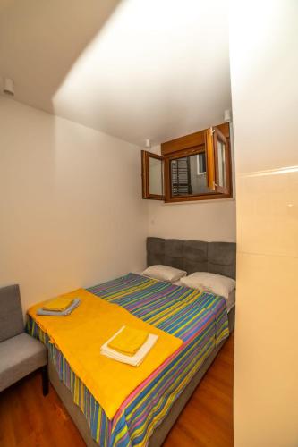 a small bedroom with a bed and a chair at Apartman Roccia in Trebinje