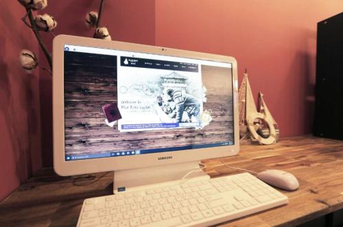 a computer monitor on a desk with a keyboard and mouse at Blueboat Hostel Jeonju in Jeonju