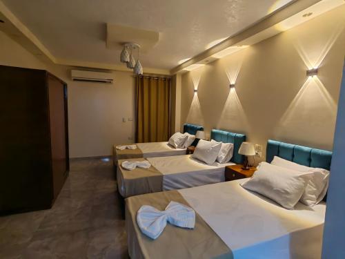 a hotel room with three beds with towels on them at Gem Overlooking inn in Cairo