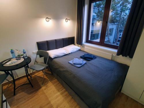 uma cama num quarto com uma mesa e uma janela em Apartamenty u Portera w Śródmieściu em Gdynia