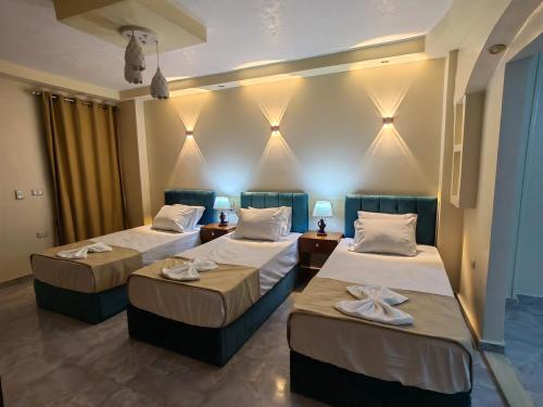 a hotel room with two beds and two lamps at Gem Overlooking inn in Cairo