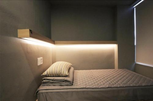a bedroom with a bed with a light on the wall at Blueboat Hostel Jeonju in Jeonju