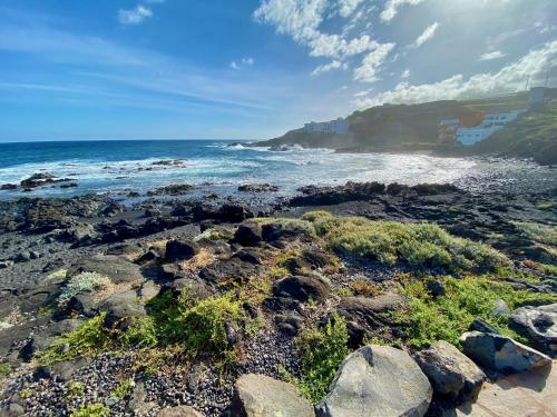 una playa con rocas y el océano en un día soleado en El estudio de Jessica en La Laguna