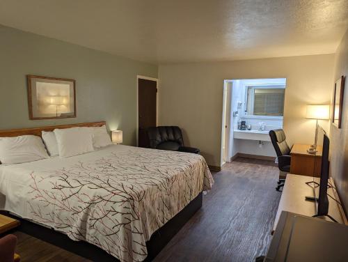 Pokój hotelowy z łóżkiem, biurkiem i oknem w obiekcie Henry's Fork Inn w mieście Saint Anthony
