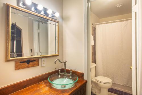 a bathroom with a sink and a toilet and a mirror at Inn At Avila Beach in Avila Beach