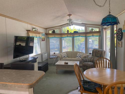 a living room with a couch and a tv at Beaver Lake Resort Site #36 in Lake Cowichan