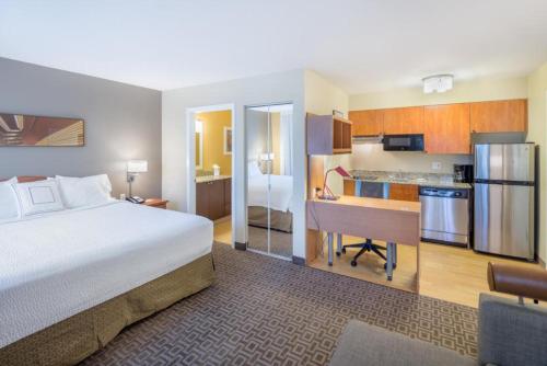 a hotel room with a bed and a desk and a kitchen at TownePlace Suites by Marriott Seattle Southcenter in Kent
