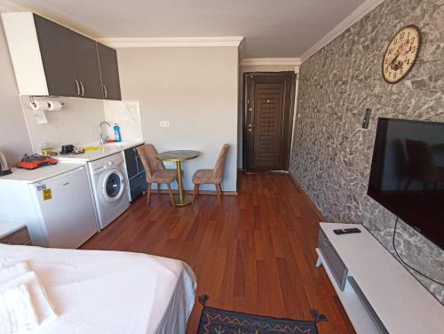 een kamer met een bed en een keuken met een magnetron bij FIRAT's Home in Istanbul