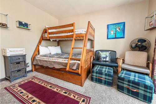 Un dormitorio con dos literas y una silla. en Ponderosa Hill Cabin - Perfect cozy escape! Located in a prime area for a family getaway!, en Big Bear City