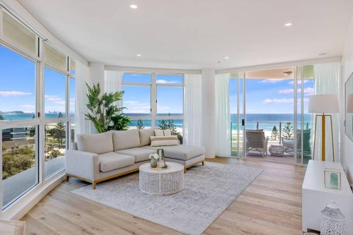 a living room with a couch and some windows at Beachfront Bliss, 3BR Kirra Oasis- Pool and Sauna in Gold Coast