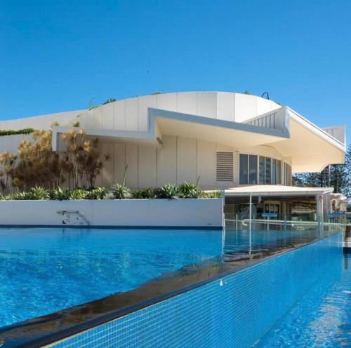 a large swimming pool in front of a building at Beachfront Bliss, 3BR Kirra Oasis- Pool and Sauna in Gold Coast