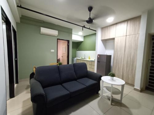 a living room with a blue couch and a table at Pacific Place Ara Damansara LRT Pool Parking Kitchen By Kenangan Homes in Petaling Jaya