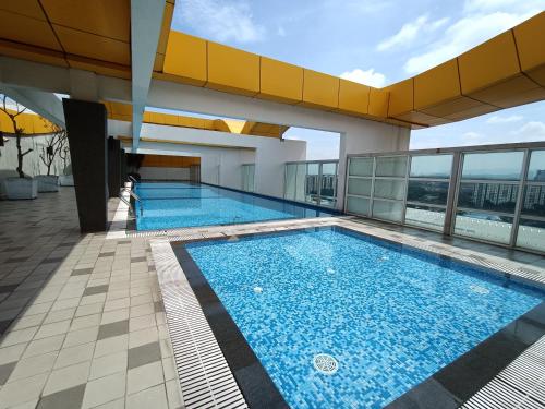 a large swimming pool on top of a building at Pacific Place Ara Damansara LRT Pool Parking Kitchen By Kenangan Homes in Petaling Jaya
