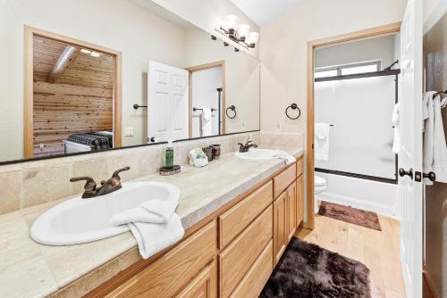 a bathroom with two sinks and a large mirror at Paradise Peak - One of kind and breathtaking log cabin with Hot Tub and Game Room! in Big Bear Lake