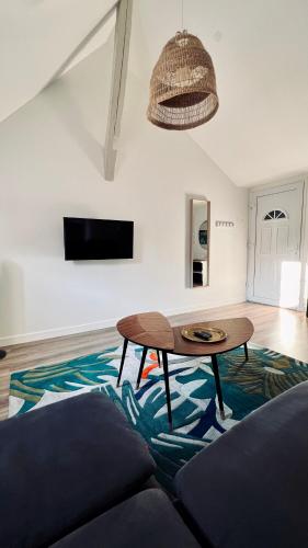 a living room with a table and a couch at RhizHome - Coeur de ville, appartement spacieux in Auxerre