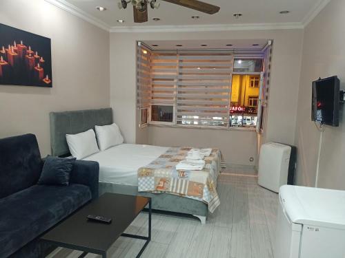 um quarto com uma cama, um sofá e uma janela em Ava suite em Istambul