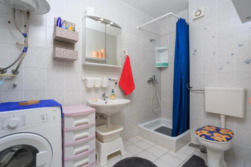 ein Badezimmer mit einer Waschmaschine und einem Waschbecken in der Unterkunft Apartments with a parking space Njivice, Krk - 20542 in Njivice