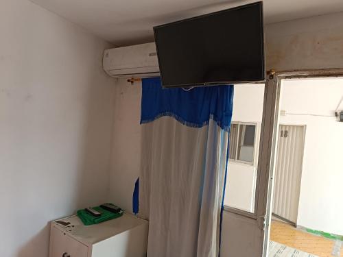 TV de pantalla plana colgada del techo de una habitación en hostal k, en Valledupar