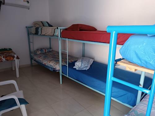 Zimmer mit 3 Etagenbetten und einem Tisch in der Unterkunft hostal k in Valledupar