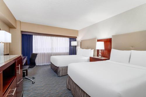 a hotel room with two beds and a desk at Crowne Plaza Hotel Los Angeles Harbor by IHG in San Pedro