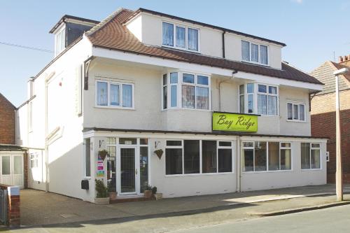 a white building with a yellow sign on it at The Bayridge Guest House in Bridlington