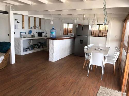 cocina y comedor con mesa y sillas en La Soñadora casa frente al mar con piscina en Canoas