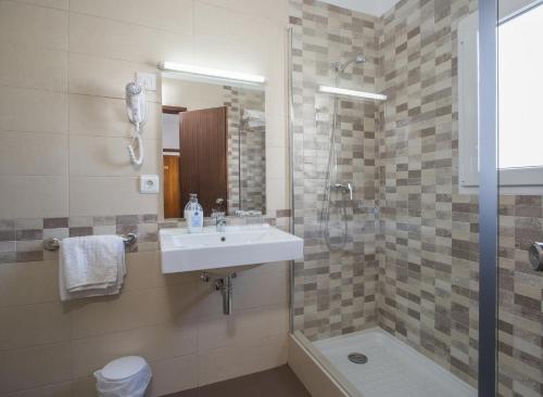 een badkamer met een wastafel en een douche bij Hostal Cervantes in San Antonio