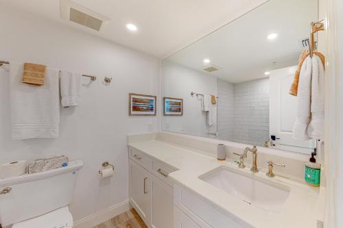 een witte badkamer met een wastafel en een spiegel bij Gulf Front Paradise in Longboat Key