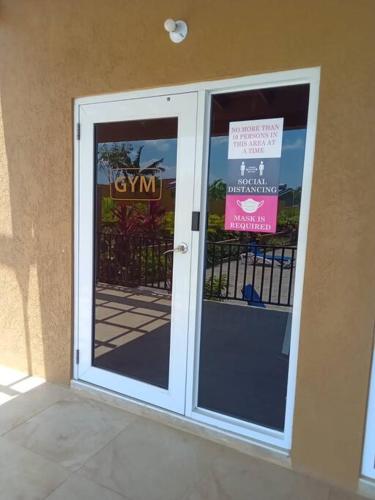 a door with a sign on it next to a building at Ocean View Get Away in Falmouth