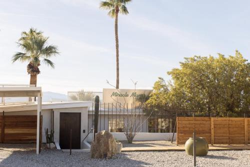 um edifício com uma palmeira em frente em Miracle Manor Boutique Hotel & Spa em Desert Hot Springs
