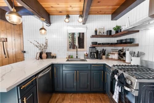 a kitchen with blue cabinets and a stove at Bearadise - Prime location for a family getaway in the winter or summer in Big Bear City