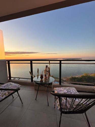 balcón con mesa, sillas y vistas al océano en Departamento en Corrientes en Corrientes