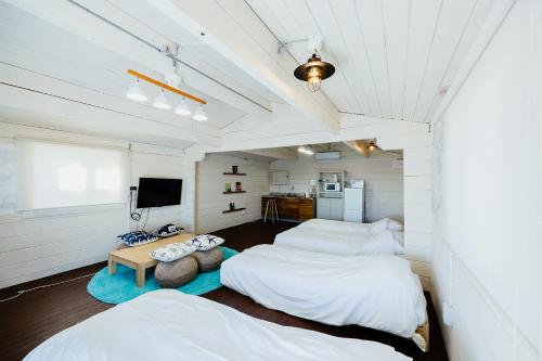 にある笹子島コテージ　スカイテラスのベッド2台とテレビが備わる客室です。
