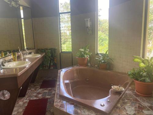 uma grande casa de banho com 2 lavatórios e uma grande banheira em Villa Pura Vida em Matapalo