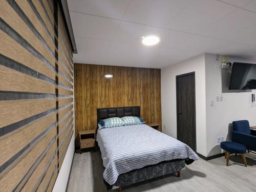 Schlafzimmer mit einem Bett und einem Flachbild-TV in der Unterkunft Cómodo y céntrico mono ambiente in La Paz