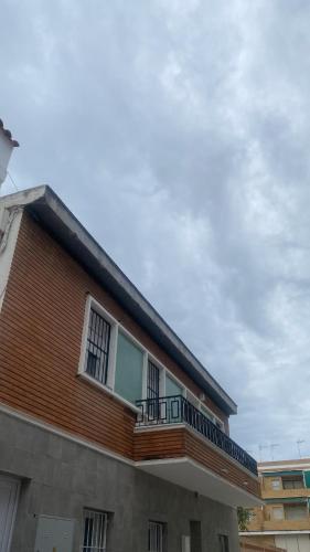 a building with a balcony on the side of it at Estancia a 600m de la playa en el centro de Punta Umbria in Punta Umbría