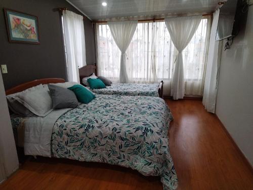 1 dormitorio con 1 cama y una ventana con cortinas en Habitación la Estación., en Paipa