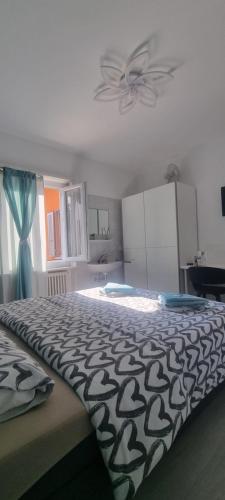 1 dormitorio con 1 cama con edredón blanco y negro en 7ROOMS Grancia, en Lugano