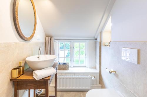 a bathroom with a sink and a mirror at De ole Hüs 1735 in Braderup