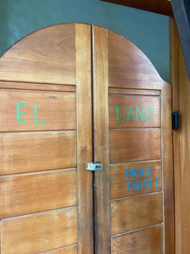 a wooden door with some writing on it at Luminosa Uvita Hostel in Uvita
