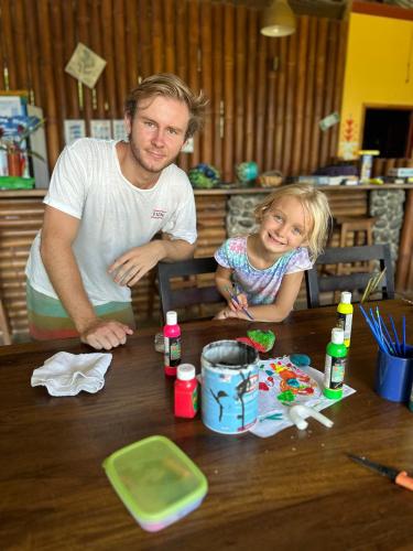 a man and a little girl sitting at a table at Luminosa Uvita Hostel in Uvita