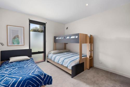 a bedroom with a bed and a bunk bed at Stage 1 in Point Lonsdale