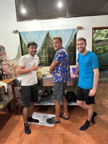 a group of three men standing in a kitchen at Luminosa Uvita Hostel in Uvita