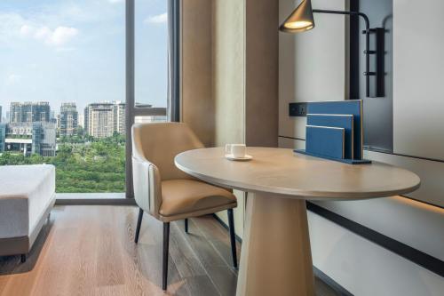 a room with a table and a bed and a window at Four Points by Sheraton Guangzhou, Baiyun in Guangzhou